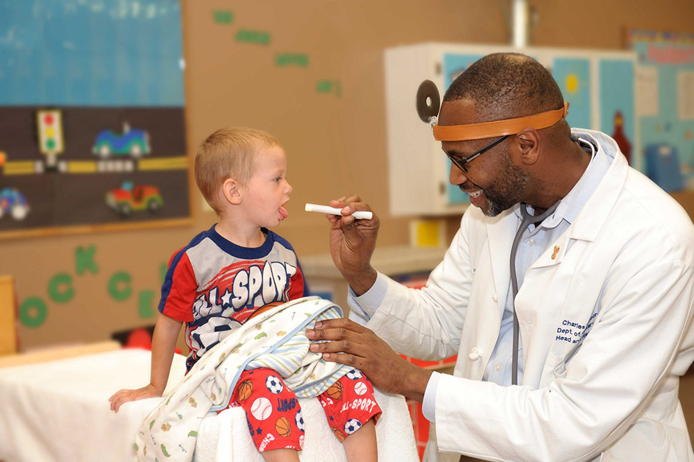 Black Doctor checking on little boy