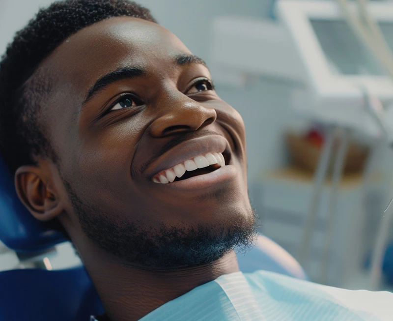 Smiling-African-american-man-sitting-in-dental-chair-in-modern-dental-clinic
