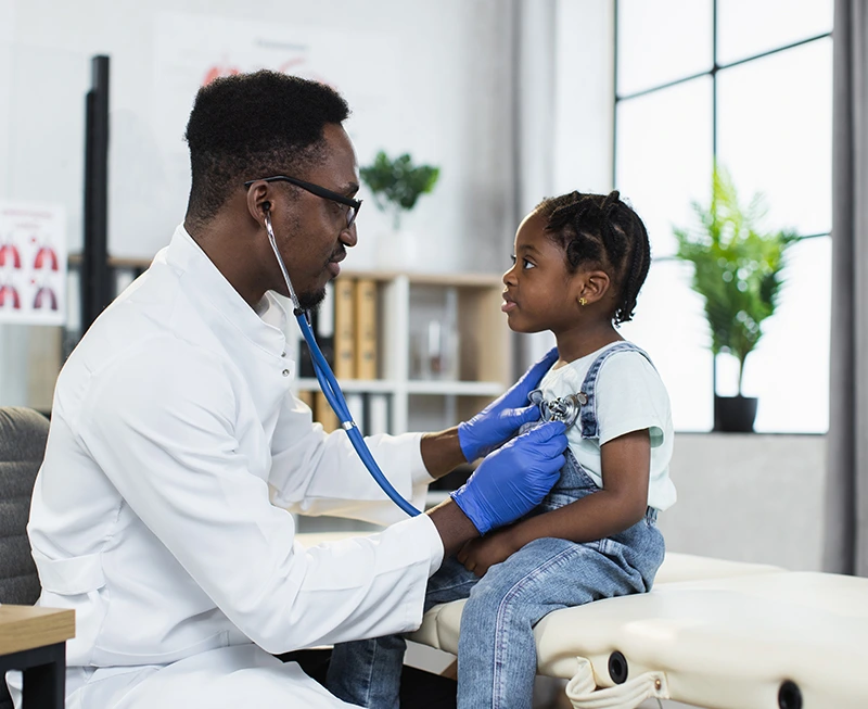 african-american-pediatrician-using-stethoscope-for-listening-little-girls-lungs-at-modern-hospital.